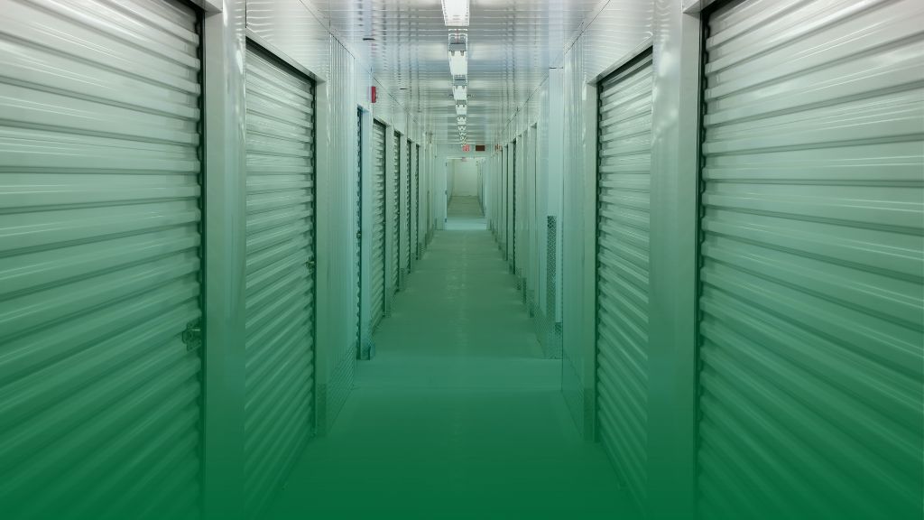 image looking down the hall of a storage unit building with garage doors on each side.